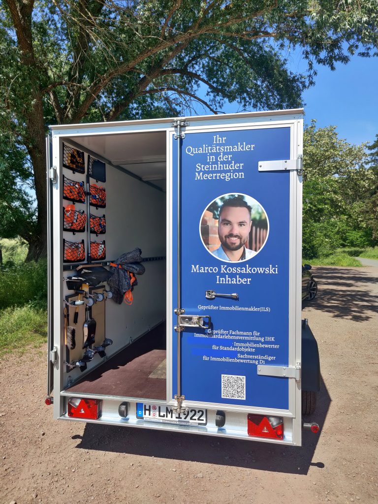 Das Bild zeigt den Anhänger der Firma Landhaus Immobilien Meerregion mit der Zusatzausrüstung für den Umzug.