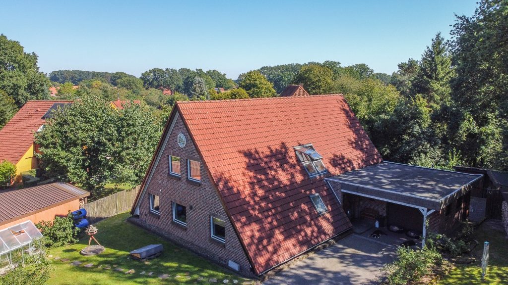 Das Nurdachhaus in der Straße Zum Uhlenberg in Bolsehle in der Vogelperspektive. Das Einfamilienhaus steht in Husum im Landkreis Nienburg zum Verkauf.